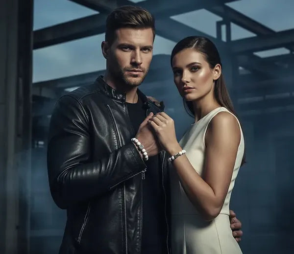 Man en vrouw dragen stijlvolle witte kralenarmbanden van Hugo Valcke, gecombineerd met een luxe moderne outfit